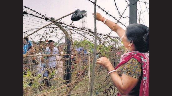 Relatives exchange gifts by attaching them to wooden rods dangled over the barbed wire. Relatives exchange gifts by attaching them to wooden rods dangled over the barbed wire.
