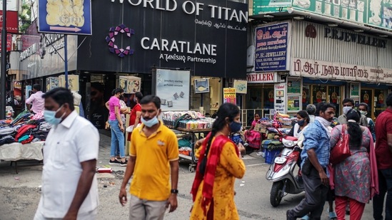 Pedestrians walk past stores in Chennai on July 1. Indian states began lifting curbs on businesses and the movement of people over the last month. The country gave a record 8.5 million vaccine doses on June 21, the first day vaccines were available for free to all adults.(Dhiraj Singh / Bloomberg)