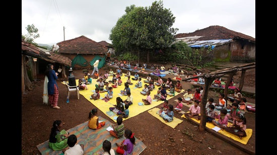 Children maintain a safe distance as they listen to pre-recorded lessons over loudspeakers in Dandwal village in Maharashtra. (File photo)