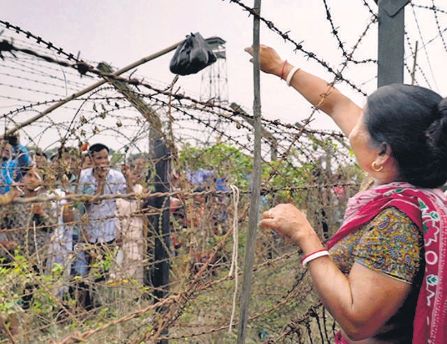Relatives exchange gifts by attaching them to wooden rods dangled over the barbed wire. Relatives exchange gifts by attaching them to wooden rods dangled over the barbed wire.