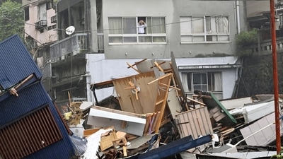 A resident looks from a window at houses that have been damaged by a mudslide following heavy rain at Izusan district in Atami, Japan on July 3. Dozens of homes may have been buried in Atami, a town known for hot springs, according to Shizuoka prefecture spokesman Takamichi Sugiyama, AP reported. (Kyodo via REUTERS) A resident looks from a window at houses that have been damaged by a mudslide following heavy rain at Izusan district in Atami, Japan on July 3. Dozens of homes may have been buried in Atami, a town known for hot springs, according to Shizuoka prefecture spokesman Takamichi Sugiyama, AP reported. (Kyodo via REUTERS)