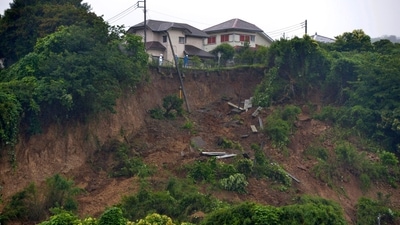 First responders observe a landslide caused by heavy rains in Zushi, Kanagawa prefecture, west of Tokyo on July 3. Torrential rains have slammed parts of Japan starting earlier this week. Experts said dirt had been loosened, increasing landslide risks in a country filled with valleys and mountains. (Kyodo News via AP) First responders observe a landslide caused by heavy rains in Zushi, Kanagawa prefecture, west of Tokyo on July 3. Torrential rains have slammed parts of Japan starting earlier this week. Experts said dirt had been loosened, increasing landslide risks in a country filled with valleys and mountains. (Kyodo News via AP)