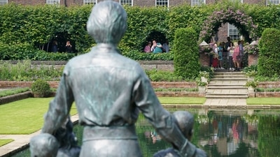 Members of the public view the statue of Britain's Princess Diana in the Sunken Garden at Kensington Palace, London, Britain July 2, 2021. The statue of the Princess has the same short, sharp hairdo she had at the time of her death, wearing a well fit blouse, a knee length skirt and a big belt as she gently placed her hand on the shoulders of the children besides her.  (REUTERS)
