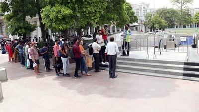 People stand in a queue to enter the metro station at Connaught Place, in New Delhi on Saturday. (ANI Photo)