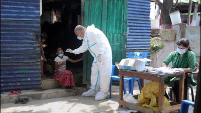 A health worker collects a nasal sample from children of slum dwellers on the outskirts of Jammu on Saturday. (PTI)