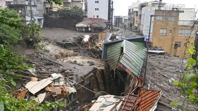 Houses damaged by a mudslide following heavy rain are seen at Izusan district in Atami on July 3. Japanese media reports said Prime Minister Yoshihide Suga called an emergency meeting for his Cabinet. (Kyodo via REUTERS) Houses damaged by a mudslide following heavy rain are seen at Izusan district in Atami on July 3. Japanese media reports said Prime Minister Yoshihide Suga called an emergency meeting for his Cabinet. (Kyodo via REUTERS)