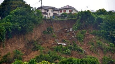 First responders observe a landslide caused by heavy rains in Zushi, Kanagawa prefecture, west of Tokyo on Saturday, July 3, 2021. In Atami in Shizuoka prefecture, authorities in Japan say multiple people are missing after a powerful mudslide swept away rows of houses. (Kyodo News via AP) First responders observe a landslide caused by heavy rains in Zushi, Kanagawa prefecture, west of Tokyo on Saturday, July 3, 2021. In Atami in Shizuoka prefecture, authorities in Japan say multiple people are missing after a powerful mudslide swept away rows of houses. (Kyodo News via AP)