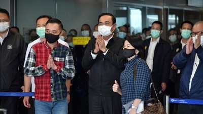 Thai Prime Minister Prayuth Chan-ocha applauds while greeting visitors arriving from Singapore. (REUTERS)