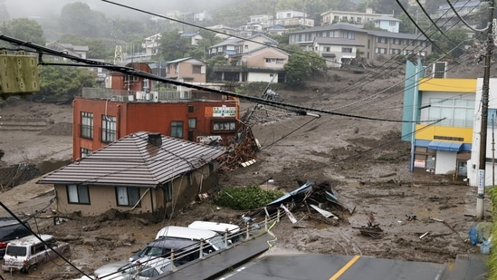 Houses and cars damaged by a mudslide following heavy rain are seen at Izusan district in Atami on July 3. NHK gave the number of missing people in Atami at 20, but Sugiyama said the prefecture confirmed at least 19, although he said the number may grow.(Kyodo via REUTERS)