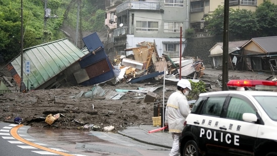 A police vehicle near houses damaged by a mudslide at Izusan district in Atami on July 3. Atami is a quaint seaside resort area in Shizuoka prefecture, about 100 kilometers southwest of Tokyo. The area that was hit by the mudslide, Izusan, includes hot springs, residential areas, shopping streets and a famous shrine.(Kyodo via REUTERS)