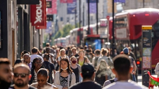 Pedestrians, some wearing face coverings due to Covid-19, walk past shops on Oxford Street in central London on June 7, 2021 (AFP)(AFP)