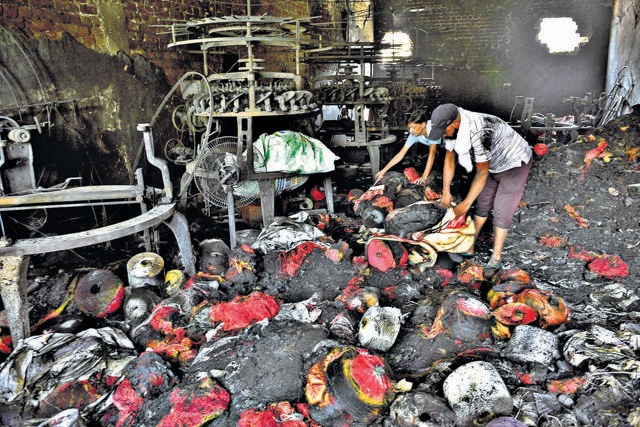 Workers sifting through damaged goods at Shivani Oswal Hosiery Unit, Kirpal Nagar, in Ludhiana, on Saturday (Gurpreet Singh/HT)