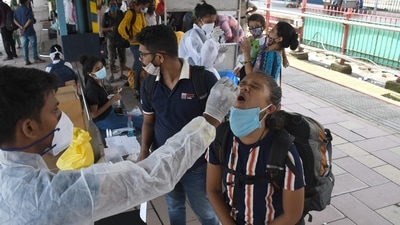 A medic collects swab samples for Covid-19 test of passengers arriving at Dadar station, in Mumbai on Saturday. (Bhushan Koyande/HT Photo)