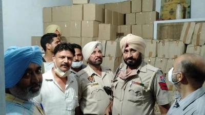 Excise department and police commissionerate officials with the fake liquor recovered from Gemco Exports, situated on GT Road in Ludhiana on Sunday. (HT PHOTO)