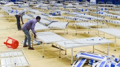 Workers dismantle beds at a Covid care centre at CWG village near Akshardham in New Delhi. (PTI) Workers dismantle beds at a Covid care centre at CWG village near Akshardham in New Delhi. (PTI)