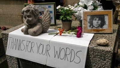 A placard, flowers and pictures are displayed on the tomb of rock singer Jim Morrison at the Pere-Lachaise cemetery in Paris, Saturday, July 3, 2021. Fans across Europe gathered at the grave of rock legend Jim Morrison to mark the 50th anniversary of his death. (AP Photo/Michel Euler) (AP) A placard, flowers and pictures are displayed on the tomb of rock singer Jim Morrison at the Pere-Lachaise cemetery in Paris, Saturday, July 3, 2021. Fans across Europe gathered at the grave of rock legend Jim Morrison to mark the 50th anniversary of his death. (AP Photo/Michel Euler) (AP)