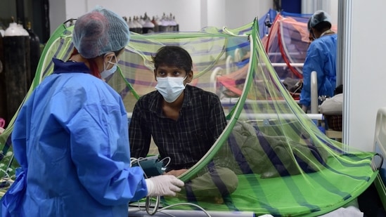 A health worker tends to a Covid-19 patient recovering at the CWG village Covid Care Centre in New Delhi, on July 4. Active cases of the coronavirus disease (Covid-19) in Delhi fell below 1000 to 992 on July 4.(Kamal Kishore / PTI)