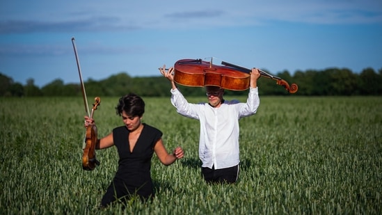 Cellist Jacob Shaw (R) and violinist Roberta Verna are pictured on a corn field on June 15 in Stevns, Denmark. Unable to perform during the pandemic, Shaw turned to an unusual audience, an experience so rewarding that he is continuing even after concert halls have reopened.(Jonathan Nackstrand / AFP)