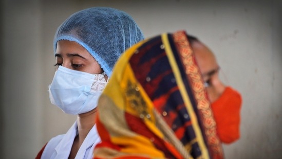 A health worker walks past a beneficiary during a vaccination drive in New Delhi, on July 2. According to government data, there were 1016 active cases in Delhi until July 3.(Manish Swarup / AP)