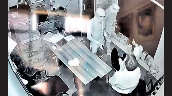A CCTV grab of the robbers pointing guns at two employees at Bhim petrol pump in Kharar in the wee hours of Sunday. (HT Photo)