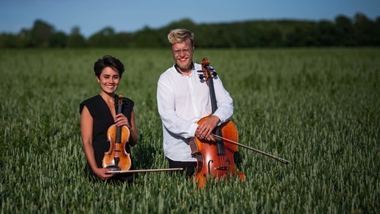 Cellist Jacob Shaw (R) and violinist Roberta Verna pose for a picture on a corn field on June 15 in Stevns, Denmark. Verna, a 22-year-old violinist, came to Stevns to "get a different perspective on things." Verna, together with Shaw, played pieces by Reinhold Gliere and Bela Bartok for the ruminants, who were seemingly as moved by the beauty of the melody as they were by the distribution of food.(Jonathan Nackstrand / AFP)