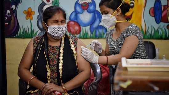 A health worker administers a dose of Covid-19 vaccine at Navyug School, Pandara Road in New Delhi on July 3. 161,110 more beneficiaries were vaccinated on July 3, of whom 121,222 received their first dose while 39,888 received their second and final dose, HT reported.(Sanchit Khanna / HT Photo)
