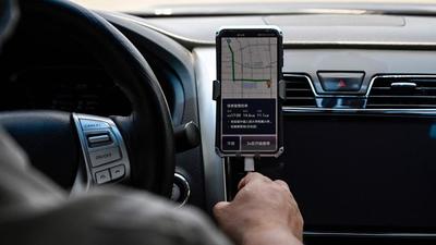 A driver uses the Didi Chuxing ride-hailing app on his smartphone while driving along the street in Beijing. (AFP/FILE) A driver uses the Didi Chuxing ride-hailing app on his smartphone while driving along the street in Beijing. (AFP/FILE)