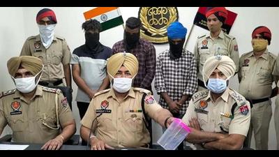 The robbery accused (in black masks) in the custody of Division Number 6 police in Ludhiana on Monday. (HT Photo) The robbery accused (in black masks) in the custody of Division Number 6 police in Ludhiana on Monday. (HT Photo)