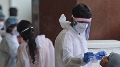 Passengers arriving on international flights get their Covid-19 screening done at the Anna International airport in Chennai. (AFP file photo) Passengers arriving on international flights get their Covid-19 screening done at the Anna International airport in Chennai. (AFP file photo)
