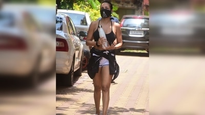 Malaika tied her locks in a sleek top bun and wore the monochrome ensemble with white-coloured sliders and a printed black face mask. (Varinder Chawla) Malaika tied her locks in a sleek top bun and wore the monochrome ensemble with white-coloured sliders and a printed black face mask. (Varinder Chawla)