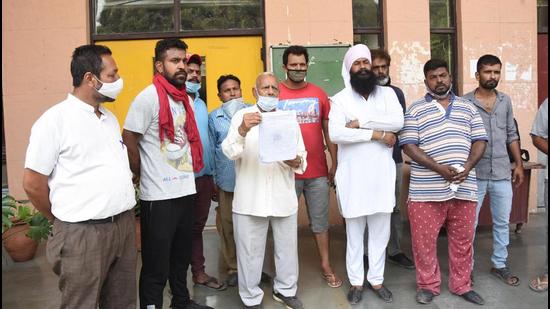 Auto-rickshaw Union members showing a copy of the memorandum before submitting it with the DC office in Ludhiana on Monday. (HT Photo)
