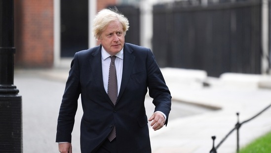 British Prime Minister Boris Johnson walks to hold a news conference for England's Covid-19 lockdown easing announcement in London.(REUTERS)