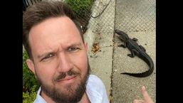 The image shows pastor Daniel Gregory of Victory church taking a selfie with the alligator.