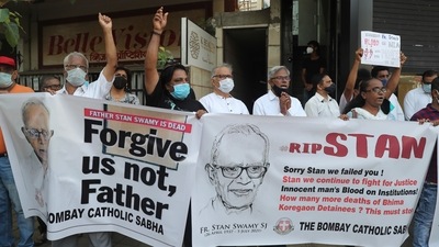 People hold banners and shout slogans during a prayer meeting for Father Stan Swamy outside a church in Mumbai, India, Tuesday, July 6, 2021. (AP) People hold banners and shout slogans during a prayer meeting for Father Stan Swamy outside a church in Mumbai, India, Tuesday, July 6, 2021. (AP)