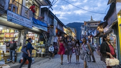 Pedestrians walk past stores at dusk in the McLeod Ganj area in Dharamshala, Himachal Pradesh, India, on Thursday, July 1, 2021. (Bloomberg)