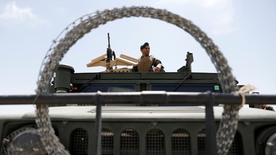 An Afghan security forces member keeps watch as he sits on an army vehicle in Bagram air base, after American troops vacated it, in Parwan province on July 5. Outside the walls of the vast base, things are not as serene. The Taliban have ramped up offensives against Afghan government forces across the country, particularly in the north where insurgents have gained territory rapidly. (Mohammad Ismail / REUTERS) An Afghan security forces member keeps watch as he sits on an army vehicle in Bagram air base, after American troops vacated it, in Parwan province on July 5. Outside the walls of the vast base, things are not as serene. The Taliban have ramped up offensives against Afghan government forces across the country, particularly in the north where insurgents have gained territory rapidly. (Mohammad Ismail / REUTERS)