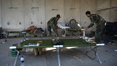 Afghan National Army (ANA) soldiers carry stretchers inside the Bagram air base after all US and NATO troops left, some 70 Kms north of Kabul on July 5. Peace talks between the Taliban and the Afghan government remain inconclusive, and many fear the country could descend into a full-blown civil war once again. (Wakil Kohsar / AFP) Afghan National Army (ANA) soldiers carry stretchers inside the Bagram air base after all US and NATO troops left, some 70 Kms north of Kabul on July 5. Peace talks between the Taliban and the Afghan government remain inconclusive, and many fear the country could descend into a full-blown civil war once again. (Wakil Kohsar / AFP)