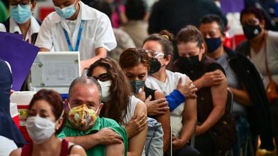 People wait after receiving doses of the Pfizer-BioNTech vaccine against Covid-19 at a vaccination centre for people over 50 years-old set up at the Vasconcelos Library, in Mexico City. (AFP/ FILE)
