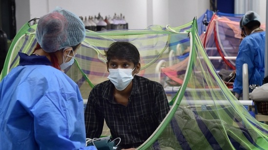 A health worker tends to a Covid-19 patient recovering at the CWG village Covid Care Centre in New Delhi. (PTI file photo) A health worker tends to a Covid-19 patient recovering at the CWG village Covid Care Centre in New Delhi. (PTI file photo)