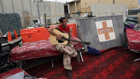 An Afghan soldier plays a guitar that was left behind after the American military departed Bagram air base, in Parwan province north of Kabul, Afghanistan on July 5. American troops handed the base over to Afghan security forces to bring an effective end to the longest war in US history, following an agreement with the insurgent Islamist Taliban last year.(Rahmat Gul / AP)