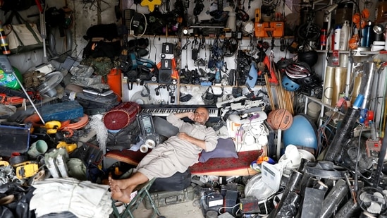 An Afghan man rests in his shop as he sell US second hand materials outside Bagram air base, after American troops vacated it, on July 5.(Mohammad Ismail / REUTERS)