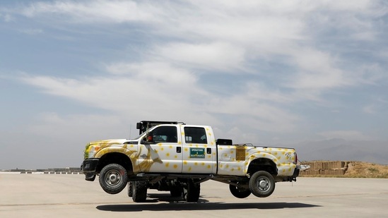 A forklift carries a vehicle in Bagram air base, after American troops vacated it, in Parwan province on July 5. On July 4, hundreds of members of the Afghan security forces fled to refuge in neighbouring Tajikistan.(Mohammad Ismail / REUTERS)