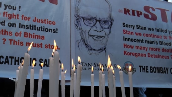 People hold posters next to candles outside a church holding memorial mass for the Indian rights activist and Jesuit priest Father Stan Swamy, in Mumbai, Tuesday, July 6, 2021. (PTI)