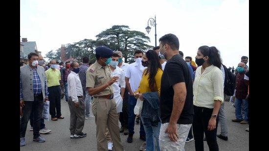 Tourists arguing with cops after being stopped for not wearing masks properly on The Ridge in Shimla on Tuesday. (Deepak Sansta/HT)
