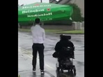 The image shows the cafe worker named Frankie helping out a customer on a wheelchair. The image shows the cafe worker named Frankie helping out a customer on a wheelchair.