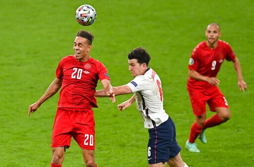 Denmark's Yussuf Poulsen, left, and England's Harry Maguire compete to head the ball during the Euro 2020 soccer championship semifinal between England and Denmark at Wembley stadium in London, Wednesday, July 7, 2021. (Justin Tallis/Pool Photo via AP)