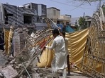 Residents remove a gate from their damaged house at the site of a car bombing in Lahore, Pakistan, on June 24, 2021. (AP) Residents remove a gate from their damaged house at the site of a car bombing in Lahore, Pakistan, on June 24, 2021. (AP)