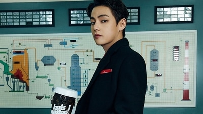 BTS member V sported a long coat and had a Louis Vuitton monogrammed coffee cup in his hand, a black messenger bag from the collection was seen placed on the desk beside him. (Instagram)