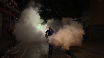 A worker in personal protective equipment sanitizes a street in the wake of a spike in the number of positive coronavirus cases, in downtown Guatemala City on July 1. At the same time, the disaster has exposed the gap between the haves and the have-nots, with vaccination drives barely getting started in Africa and other desperately poor corners of the world because of extreme shortages of shots. (Moises Castilo / AP)