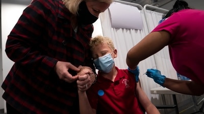 Heather Haworth (L), holds the hand of her 12-year-old son Jeremy as he receives the first dose of the Pfizer Covid-19 vaccine in Santa Ana, California on May 13. The variants, uneven access to vaccines and the relaxation of precautions in wealthier countries are “a toxic combination that is very dangerous,” warned Ann Lindstrand, a top immunization official at the World Health Organization. (Jae C. Hong / AP)